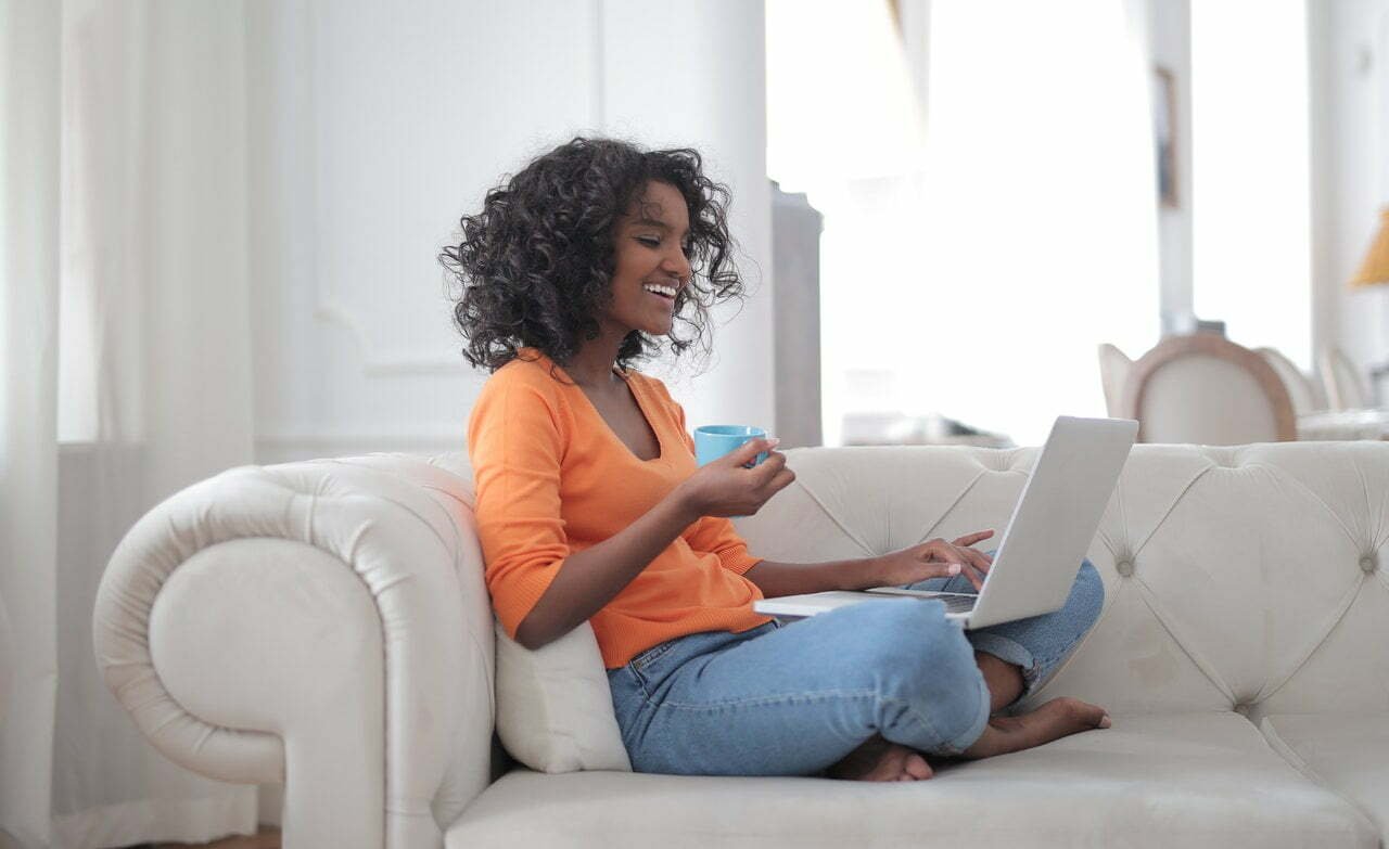 cheerful-woman-with-cup-of-coffee-surfing-laptop-3960563